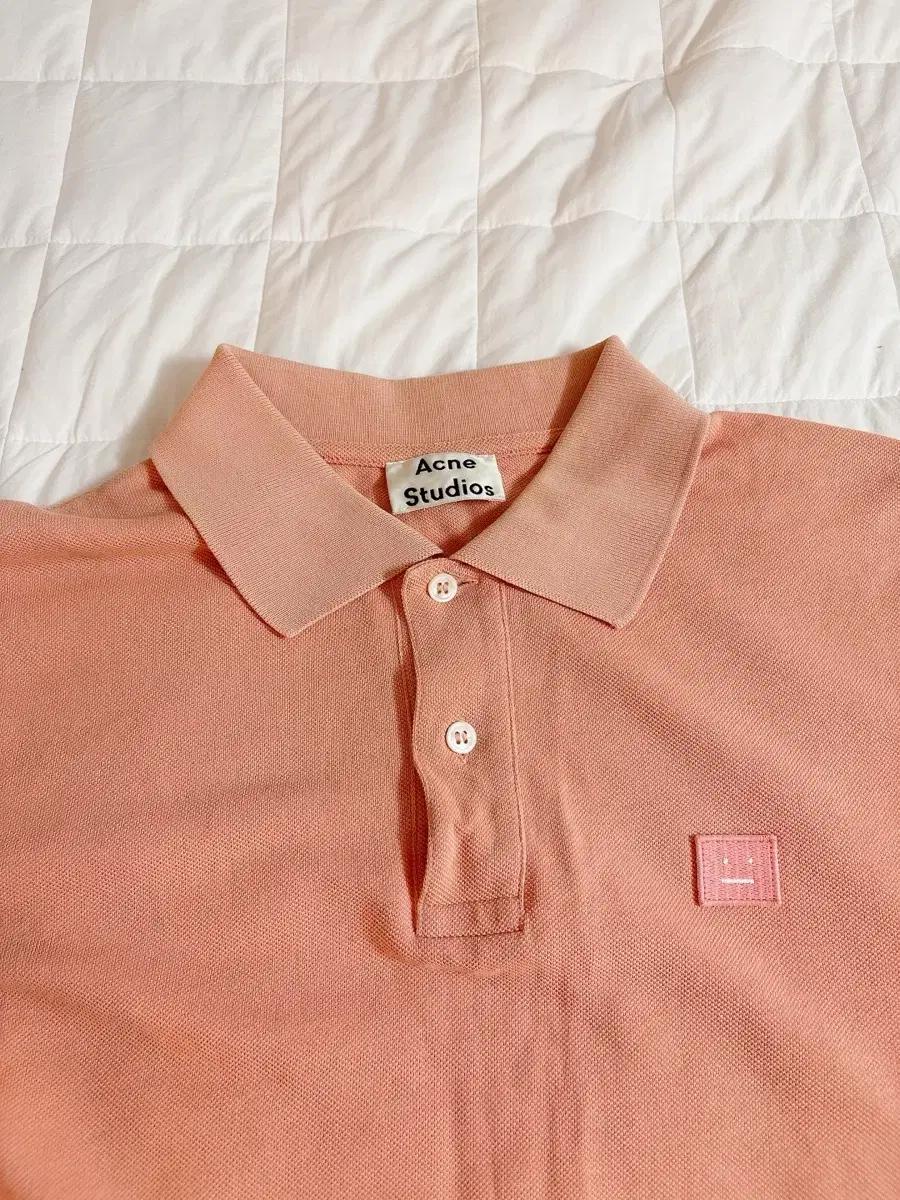 아크네 스튜디오 피치컬러 Falco Face PSS17 폴로 셔츠입니다.